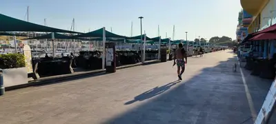 a man walking down a boardwalk at Pateo Apartment - One Bedroom in Albufeira in Albufeira