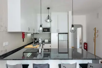a kitchen with white cabinets and a counter top at Pateo Apartment - One Bedroom in Albufeira in Albufeira