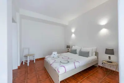 a bedroom with a white bed and a table at Pateo Apartment - One Bedroom in Albufeira in Albufeira
