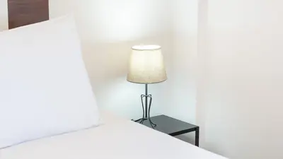 a lamp sitting on a table next to a bed at Sunny Retreat with Pool and Balcony by LovelyStay in Albufeira