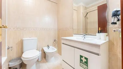 a bathroom with a toilet and a sink at Sunny Retreat with Pool and Balcony by LovelyStay in Albufeira