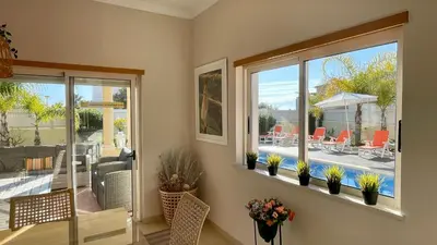 a living room with two windows and a view of a patio at Sunshine by Check-in Portugal in Albufeira