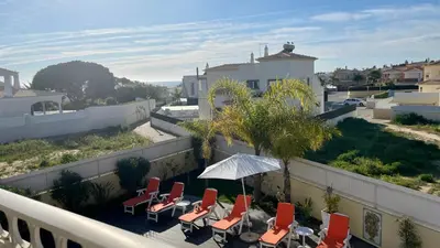 a patio with chairs and an umbrella on a balcony at Sunshine by Check-in Portugal in Albufeira