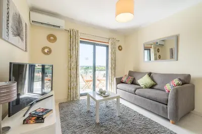 a living room with a couch and a tv at Vista Das Ondas 308 By RS in Olhos de Água