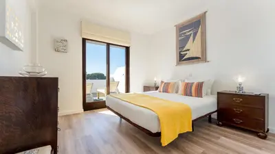 a bedroom with a bed with a yellow blanket on it at Balaia Project by LovelyStay in Olhos de Água