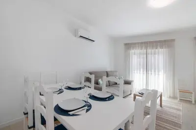 a white dining room with a white table and chairs at Refúgio Estrela do Mar in Quarteira