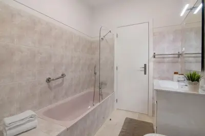a bathroom with a tub and a sink and a shower at Refúgio Estrela do Mar in Quarteira