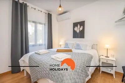 a bedroom with a bed with a home holidays sign on it at #242 Old Town - Casa de Albufeira 2 by Home Holidays in Albufeira