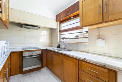 a kitchen with wooden cabinets and a sink and a window at TAC - Villa Oura in Albufeira