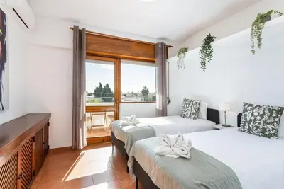 a room with three beds and a window at TAC - Villa Oura in Albufeira