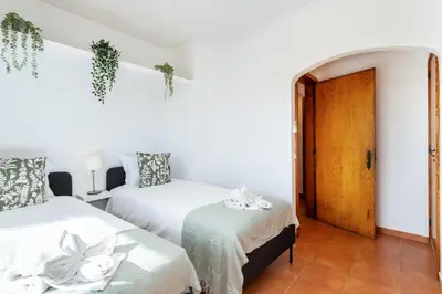 a bedroom with two beds and a door at TAC - Villa Oura in Albufeira
