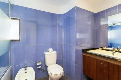 a blue tiled bathroom with a toilet and a sink at TAC - Villa Oura in Albufeira