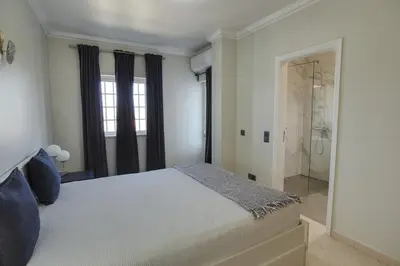 a white bedroom with a bed and a shower at 3 Bed Vacation home in Quarteira in Quarteira