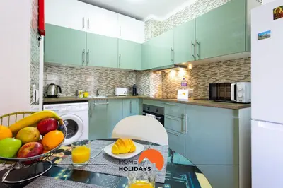 a kitchen with blue cabinets and a table with fruit on it at #287 Rodrimar Studio 212 by Home Holidays in Albufeira