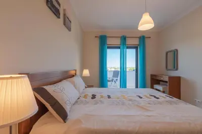 a bedroom with a bed and a window with a view at Vista das Ondas 208 by JS in Olhos de Água