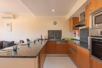 a kitchen with wooden cabinets and a counter top at Vista das Ondas 208 by JS in Olhos de Água