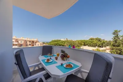 a table and chairs on a balcony with a view at Vista das Ondas 208 by JS in Olhos de Água
