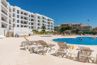 a pool with chairs and a table and a swimming pool at Vista das Ondas 208 by JS in Olhos de Água