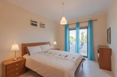 a bedroom with a bed and a large window at Vista das Ondas 208 by JS in Olhos de Água