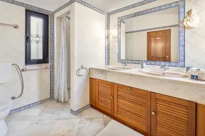a bathroom with a sink and a mirror and a toilet at Villa Coral by OCvillas in Albufeira