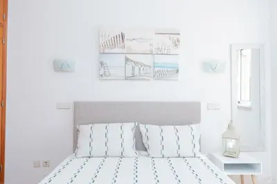 a living room with a blue couch and a kitchen at Casa da Praia by OCvillas in Albufeira