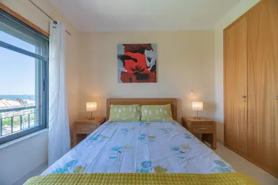 a bedroom with a bed and a window at Vista das ondas 205 by AS in Olhos de Água