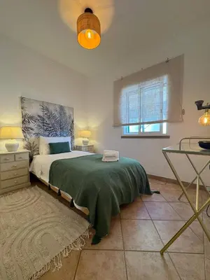a bedroom with a large bed and a window at Cosy 3 bed Apartment Albufeira Old town in Albufeira