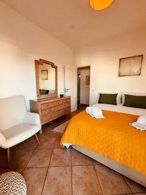 a bedroom with a bed and a chair and a mirror at Cosy 3 bed Apartment Albufeira Old town in Albufeira