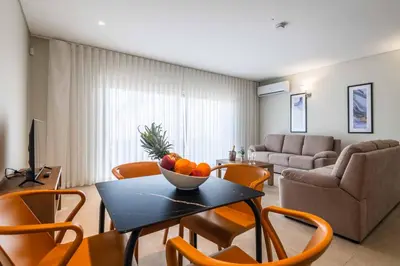 a living room with a table with a bowl of fruit on it at DK Stays Residences Albufeira in Albufeira