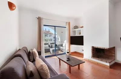 a living room with a couch and a fireplace at Alta Oura in Albufeira