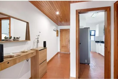 a kitchen with white walls and wooden floors and a doorway at Alta Oura in Albufeira