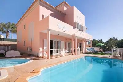 a villa with a swimming pool in front of a house at Solar das Andorinhas in Albufeira