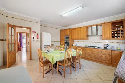a kitchen with a table and chairs in a room at Solar das Andorinhas in Albufeira