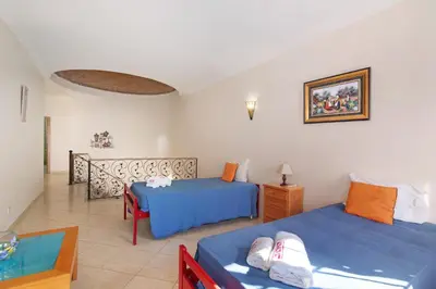 a hotel room with two beds and a balcony at Solar das Andorinhas in Albufeira