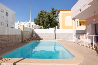 a swimming pool in a yard next to a house at Solar das Andorinhas in Albufeira