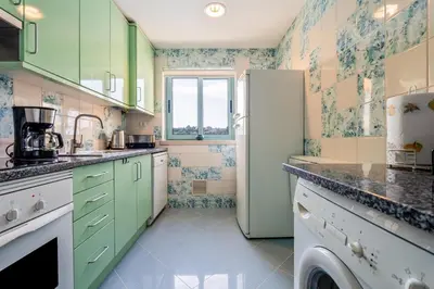 a kitchen with green cabinets and a refrigerator at Marina 4B 1D By RS in Albufeira