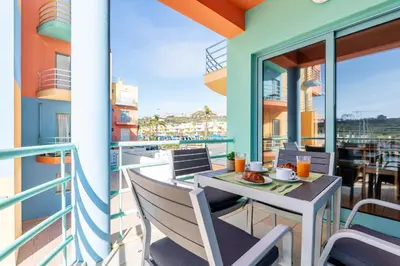 a balcony with a table and chairs and a view of the ocean at Marina 4B 1D By RS in Albufeira