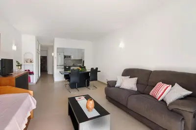 a dining room and living room with a table and chairs at Apartament Dita in Albufeira