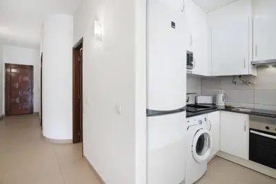 a kitchen with a white refrigerator and a washing machine at Apartament Dita in Albufeira