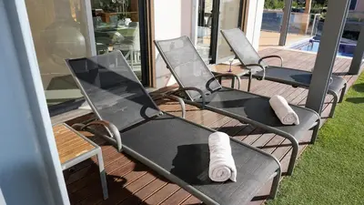 a row of chairs sitting on top of a deck at Luxury 3 Bedroom, 3 ensuits, Private pool, Vale do Lobo in Loulé
