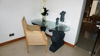 a glass table with two chairs and a vase on it at Luxury 3 Bedroom, 3 ensuits, Private pool, Vale do Lobo in Loulé