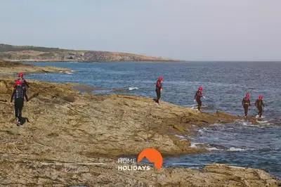 a group of people walking on the rocks near the water at #284 Vista das Ondas by Home Holidays in Albufeira