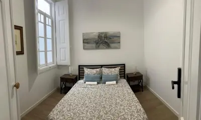 a bedroom with a bed with a speaker on the wall at Yellow Guesthouse in Faro