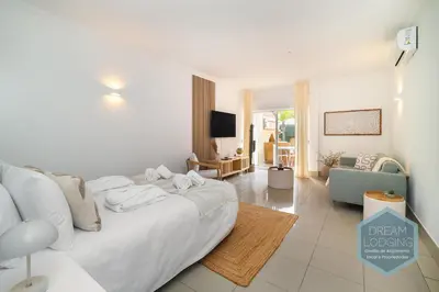 a bedroom with a white bed and a living room at Casablanca - Dream Lodging in Albufeira
