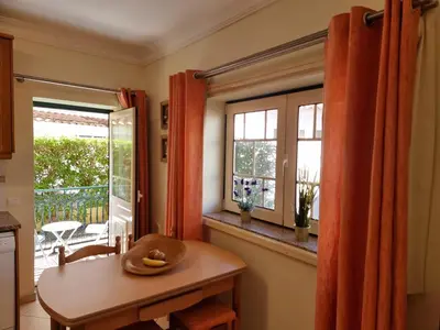 a kitchen with a table and two windows and a table at Oasis Apartment in Albufeira