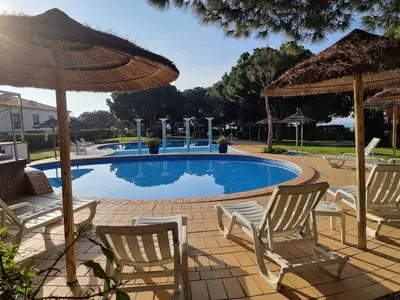 a swimming pool with chairs and an umbrella at Oasis Apartment in Albufeira