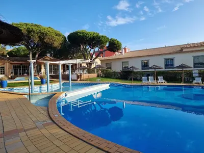 a swimming pool with blue water in front of a building at Mar à Vista Apartment in Albufeira