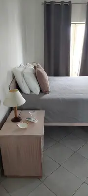 a bedroom with a bed with pillows and a table at Mar à Vista Apartment in Albufeira