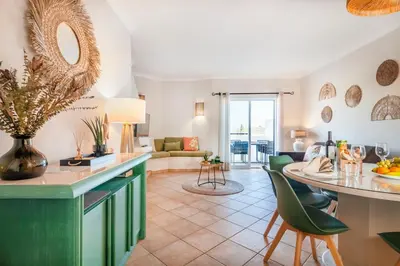a kitchen and living room with a table and chairs at Our House in Clube Albufeira in Albufeira