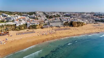 a large blue swimming pool with umbrellas at Our House in Clube Albufeira in Albufeira